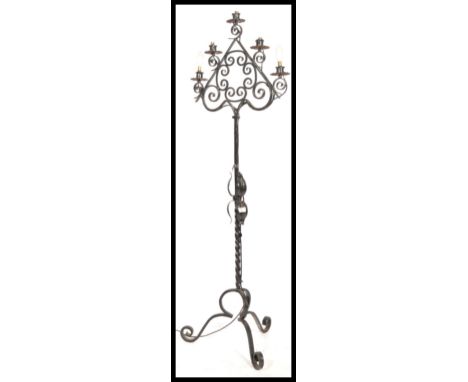 A 20th century wrought metal ebonised standard lamp having twist column with scrolled leg supports having a 5 branch candle t