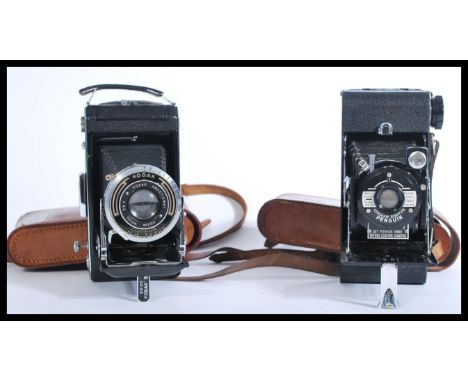 A vintage 20th Century leather cased folding Penguin camera together with another similar camera by Kodak again with leather 