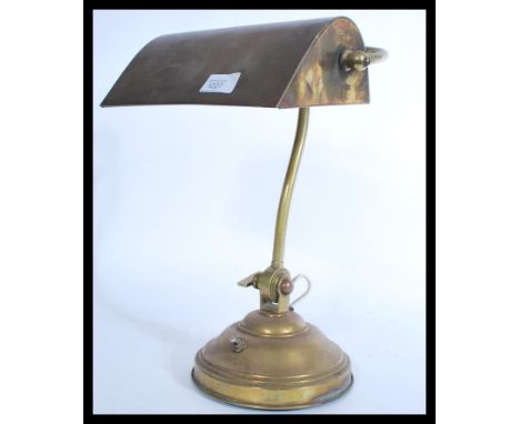 A vintage mid century brass bankers lamp raised on terraced base having angular and adjustable shade. Measures 37 cm high.