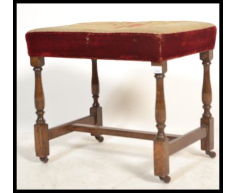 A late 19th century oak tapestry upholstered ecclesiastical stool. The oak frame with turned legs having brass castors with s
