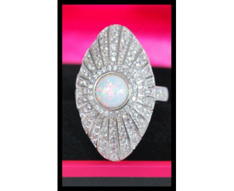 A sterling silver art deco style opal and marcasite dress ring of shield form having a central opal.