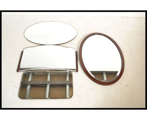 A collection of four vintage and antique mirrors to include three framless mirrors together with another having an mahogany f
