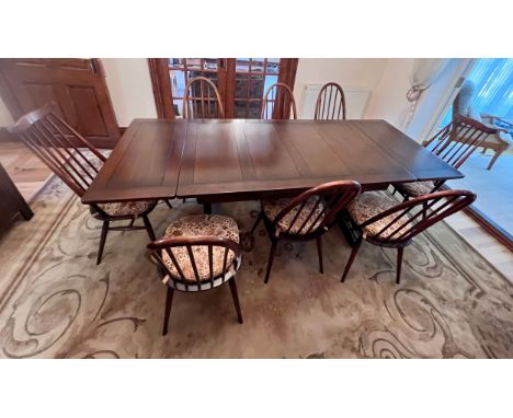 Ercol drawer leaf dining table with eight Ercol chairs, six and two. One chair with blue label, two with gold label. Closed 1