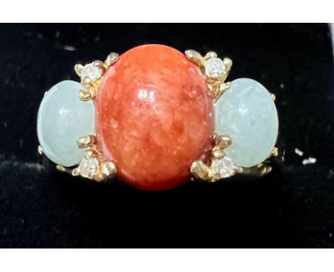 A jadeite and diamond ring, the red jadeite cabochon flanked by green jadeite cabochons interspaced with round brilliant cut 