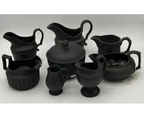 A group of early 19th century black basalt engine turned and moulded creamers and a lidded sugar, c. 1810. Including two mark