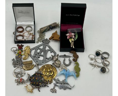 A quantity of costume jewellery to include silver rings, various brooches, a RAC car badge.