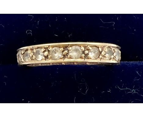 A yellow metal eternity ring set with clear stones. Size K. Weight 2.2gm.