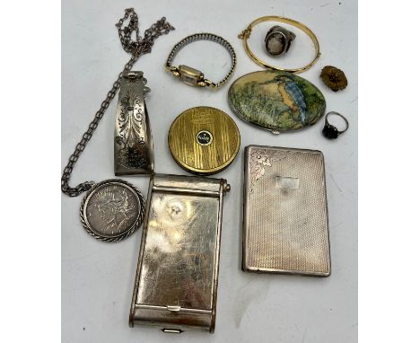 A miscellany to include vintage compacts, Victorian skirt lift, one dollar pendant, .900 silver ring, cigarette case etc.