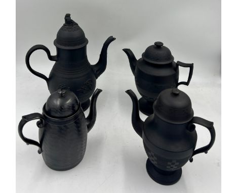 A group of early 19th century black basalt coffee pots and covers, c. 1810. Some are engine turned, one with smear glaze and 