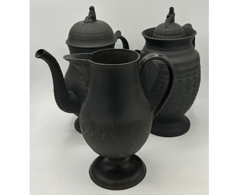 A group of early 19th century engine turned black basalt wares, c. 1810. To include two lidded coffeepots, and a tall jug. Ta