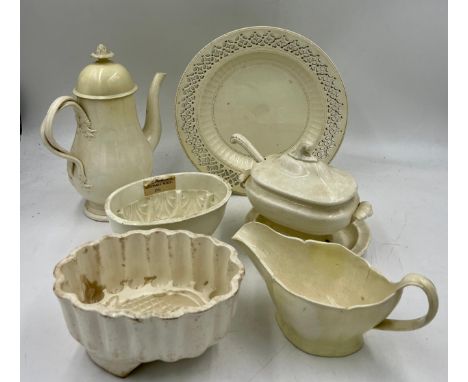 A group of early 19th century creamware, c. 1810. To include: a coffeepot and cover, a sauce boat, two Spode jelly moulds, a 