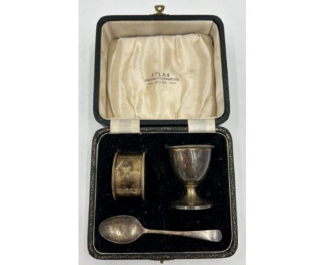 A hallmarked cased silver christening set consisting of egg cup, spoon and napkin ring, Adie Brothers Ltd, Birmingham 1955. T