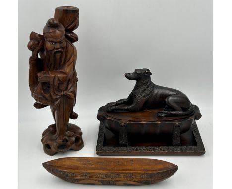 Three wooden carved items comprising a dog inkwell 20cm h, base 27.5 x 16.5cm, an Oriental figure candlestick holder 36cm h a