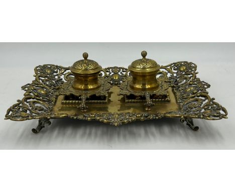 An ornate early 20thC brass double inkwell with pen stand. 34 x 27cm.