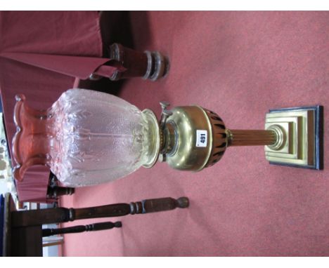 A Circa 1900 Brass Paraffin Lamp, moulded clear and cranberry glass shade, brass reservoir and reeded column, on triple squar
