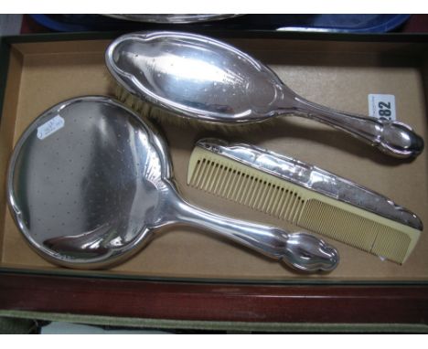 A Hallmarked Silver Backed Hand Mirror, a brush and a comb. (3)