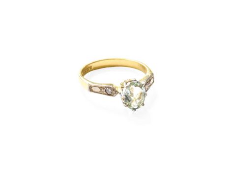 An 18 Carat Gold Aquamarine Ring, the oval cut aquamarine in a white claw setting, to round brilliant cut diamond set shoulde