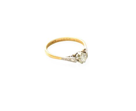 A Diamond Solitaire Ring, the round brilliant cut diamond in a white claw setting, to a yellow tapered shoulder plain polishe