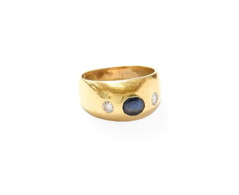 A Sapphire and Diamond Three Stone Ring, the yellow plain polished band inset with an oval cut sapphire and two round brillia