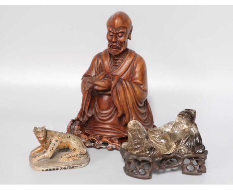 A Chinese Carved Rock Crystal Figure of a Reclining Scholar, 10cm length, on carved base; a similar carved hardwood figure on