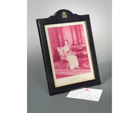 HM Queen Elizabeth II, a signed photograph dated 1973 (some discolouration) in official morocco leather frame; together with 