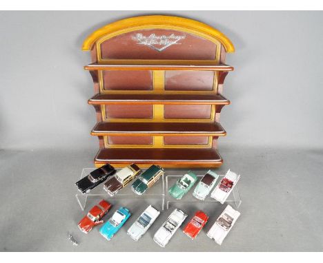 Franklin Mint - A Franklin Mint wooden wall display containing 12 1:43 scale diecast 'Classic Cars of the 50's'. Lot includes