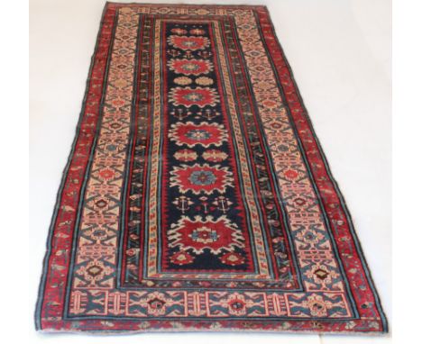 A Shirvan Caucasian corridor carpet - late 19th century, the blue field with six red flowerheads, within a mid-blue and ivory