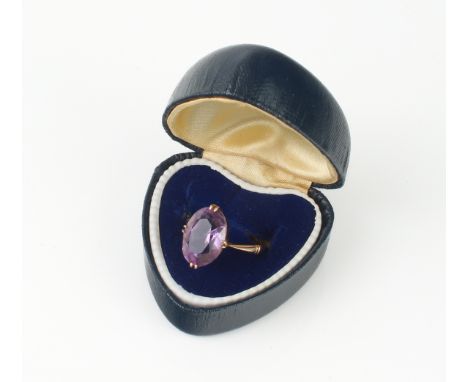 A vintage 9ct rose gold and amethyst ring - the 13 x 9.5mm oval cut amethyst in a four claw setting over tapered shoulders, s