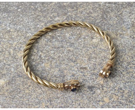 A 9ct gold bangle set with sapphires and diamonds