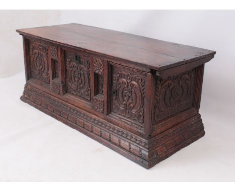 An Italian 18th&nbsp;century carved walnut cassone &ndash; the two-plank top over panelled sides and a three-panel front, car