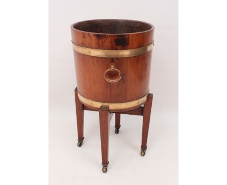 A coopered teak jardiniere on mahogany stand -&nbsp;first half 20th century in 19th century style,&nbsp;the brass-bound jardi