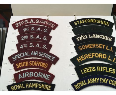 An album containing cloth embroidered Army shoulder titles. mounted on on ten cards.