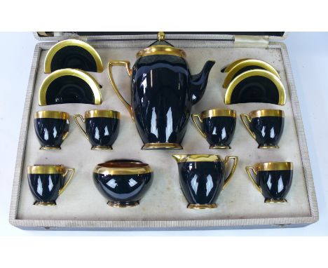 An Art Deco Carltonware coffee service
Decorated with a plain black glazed body with gilt rims, fitted in original box, print