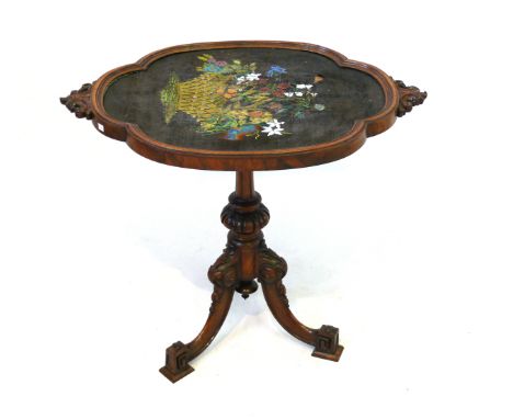 A Victorian carved walnut occasional table
The shaped top with inset bead work panel, raised on turned and fluted column and 