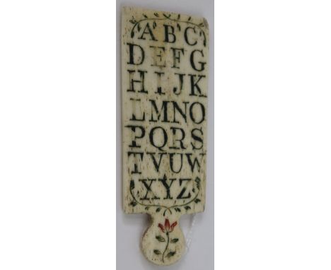 A bone children's alphabet board 19th Century
The panel with shaped handle decorated with flowers with capital letters to one