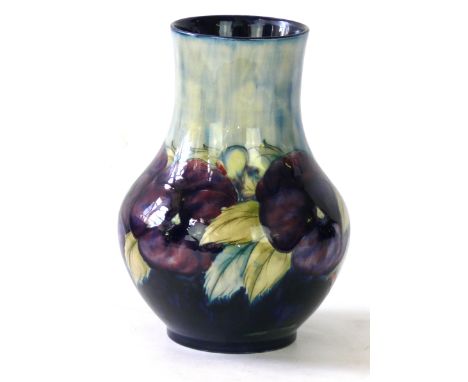 A William Moorcroft pottery vase of baluster form
Decorated in the Pansy pattern on a clear and blue ground, green signature 