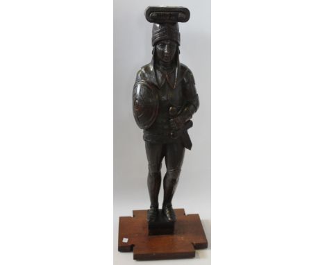 A carved oak figure of a knight early 20th Century
The figure in armour holding a sword and shield, his helmet surmounted by 