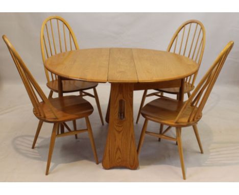 An Ercol light elm Windsor dining suite 
Comprising a drop-leaf dining table, model number 1156, height 73cm, four spindle ba