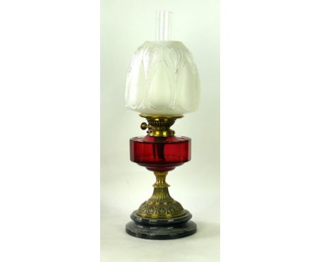 A 20th Century brass paraffin lamp
Having a cranberry glass reservoir, raised on cast plinth base, with frosted glass shade, 