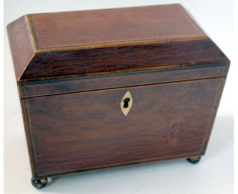 An inlaid mahogany sarcophagus shape tea caddy early to mid 19th Century
The canted lid lifts up to reveal two sections with 