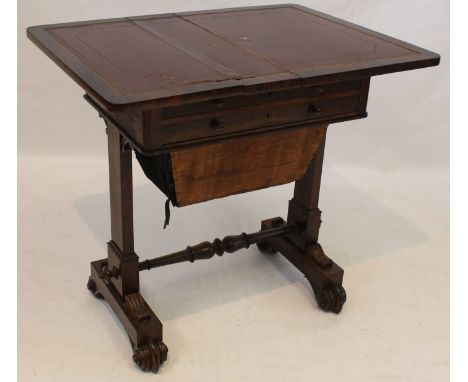 A Victorian rosewood card/work table
The hinged and swivel top above two frieze drawers and sliding fabrics bag, raised on ar