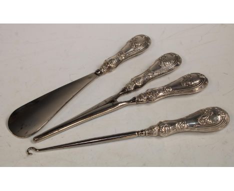 A George V set of three silver hafted lady's dressing table accessories, glove stretchers, shoe horn, button hook, embossed w