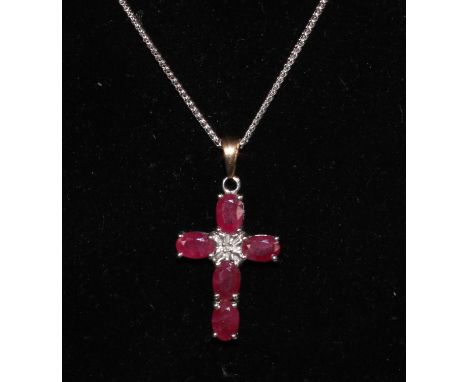 A ruby and diamond accented 9ct white gold cross pendant, suspended from an 18ct white gold necklace, 5g gross