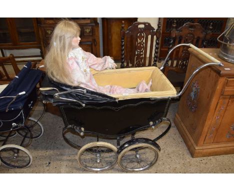 A vintage black pram together with a large porcelain body doll