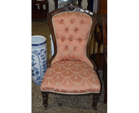 A pink upholstered button back chair