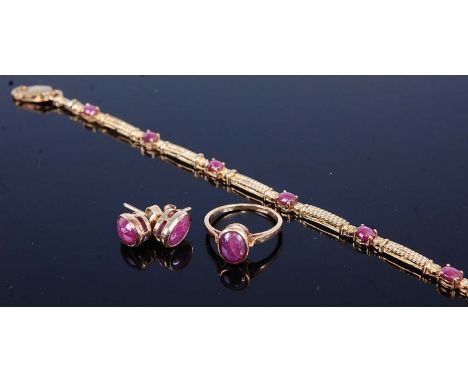 A yellow metal ruby bracelet, earring and ring suite, the bracelet comprising seven oval cabochon cut rubies alternating with