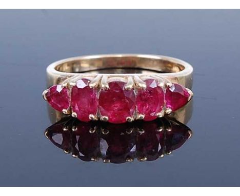 A 14ct yellow gold ruby five stone half hoop ring, with three graduated oval and two triangular faceted rubies, all in claw s