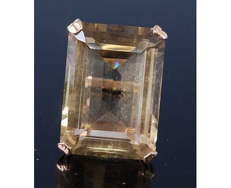 A 9ct yellow gold and lemon quartz dress ring, featuring a large emerald cut citrine in a four claw setting with an open scro