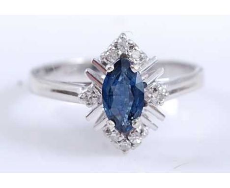 A white metal, sapphire and diamond navette shaped cluster ring, featuring a centre marquise cut sapphire within a border of 