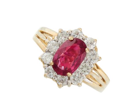 RUBY AND DIAMOND RING in cluster form set with an oval cut ruby of 1.31 carats in a border of round cut diamonds totalling 0.